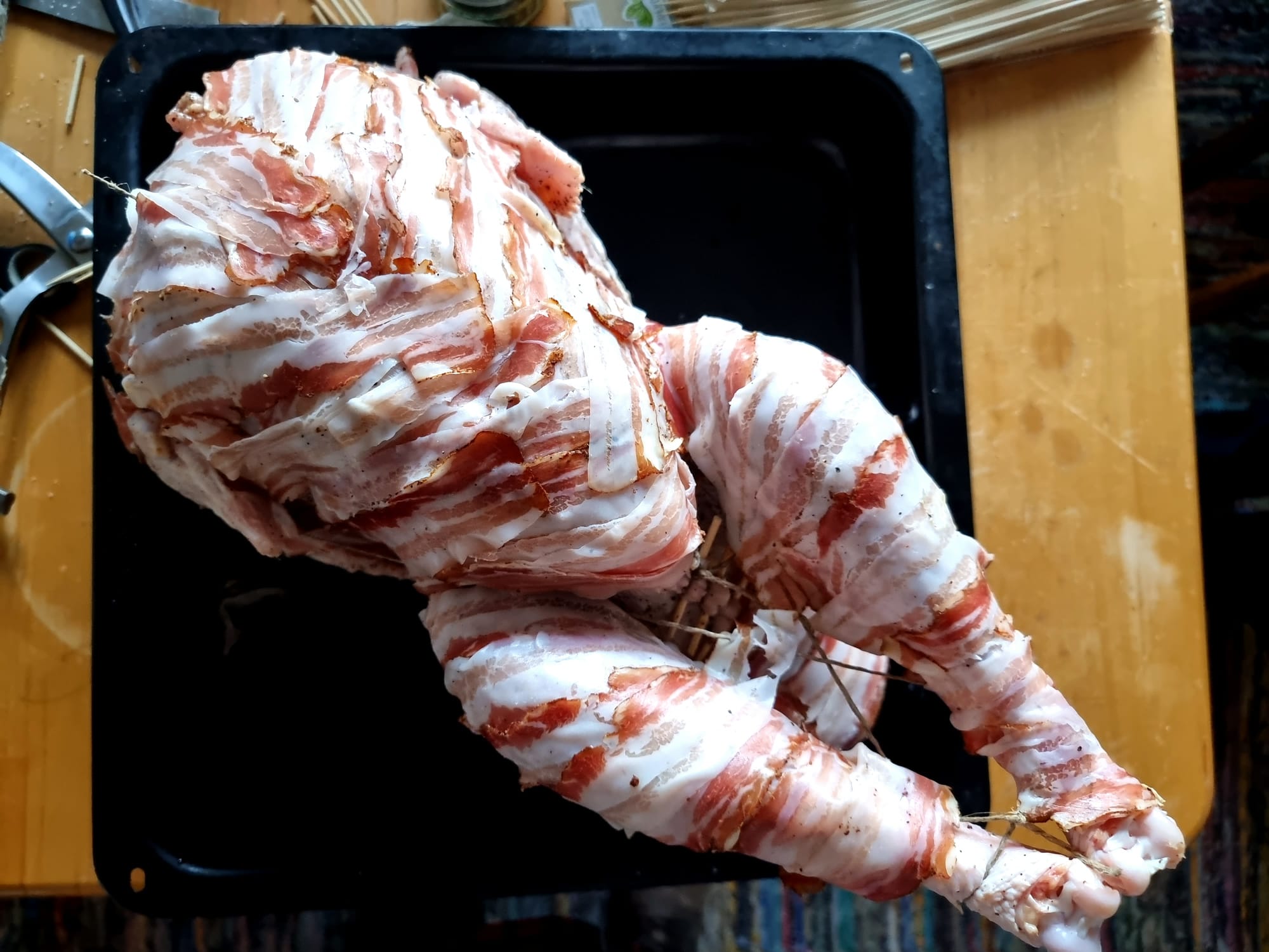 A raw and trussed turkey, dressed in bacon