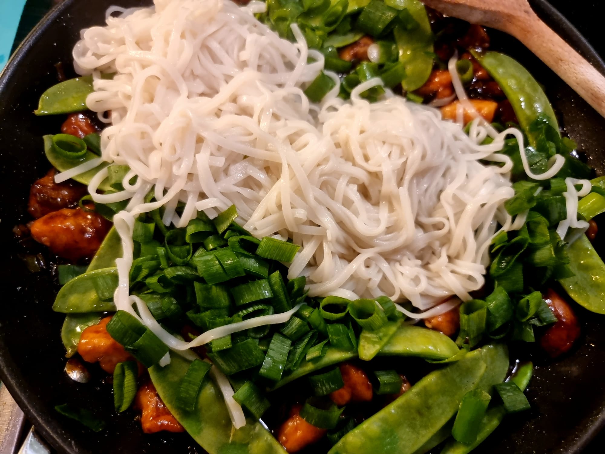 A pan filled with hoisin chicken, green vegetables and a good helping of noodles.