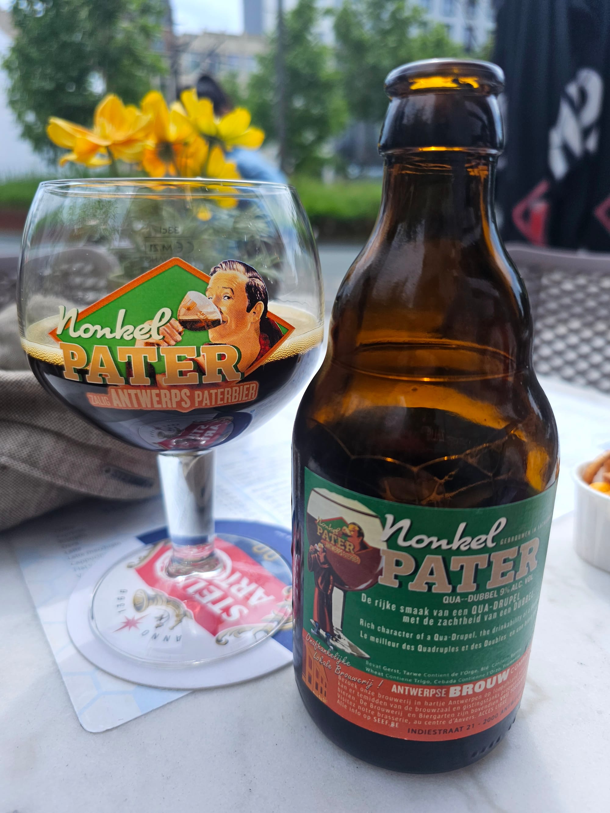 A bottle of Nonkel Pater Antwerp beer, with a half filled glass next to it 