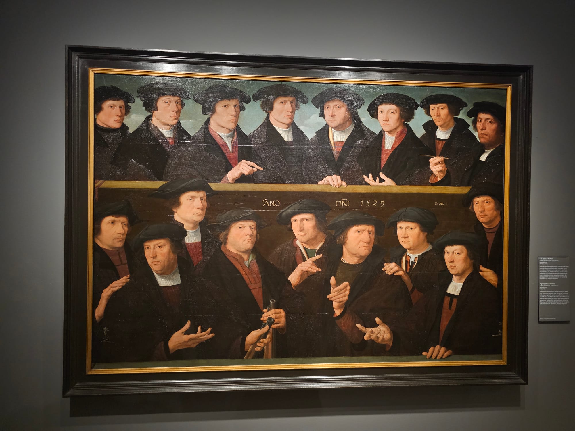 A group of Dutch guardsman who look very similar and seem to be pointing at each other 