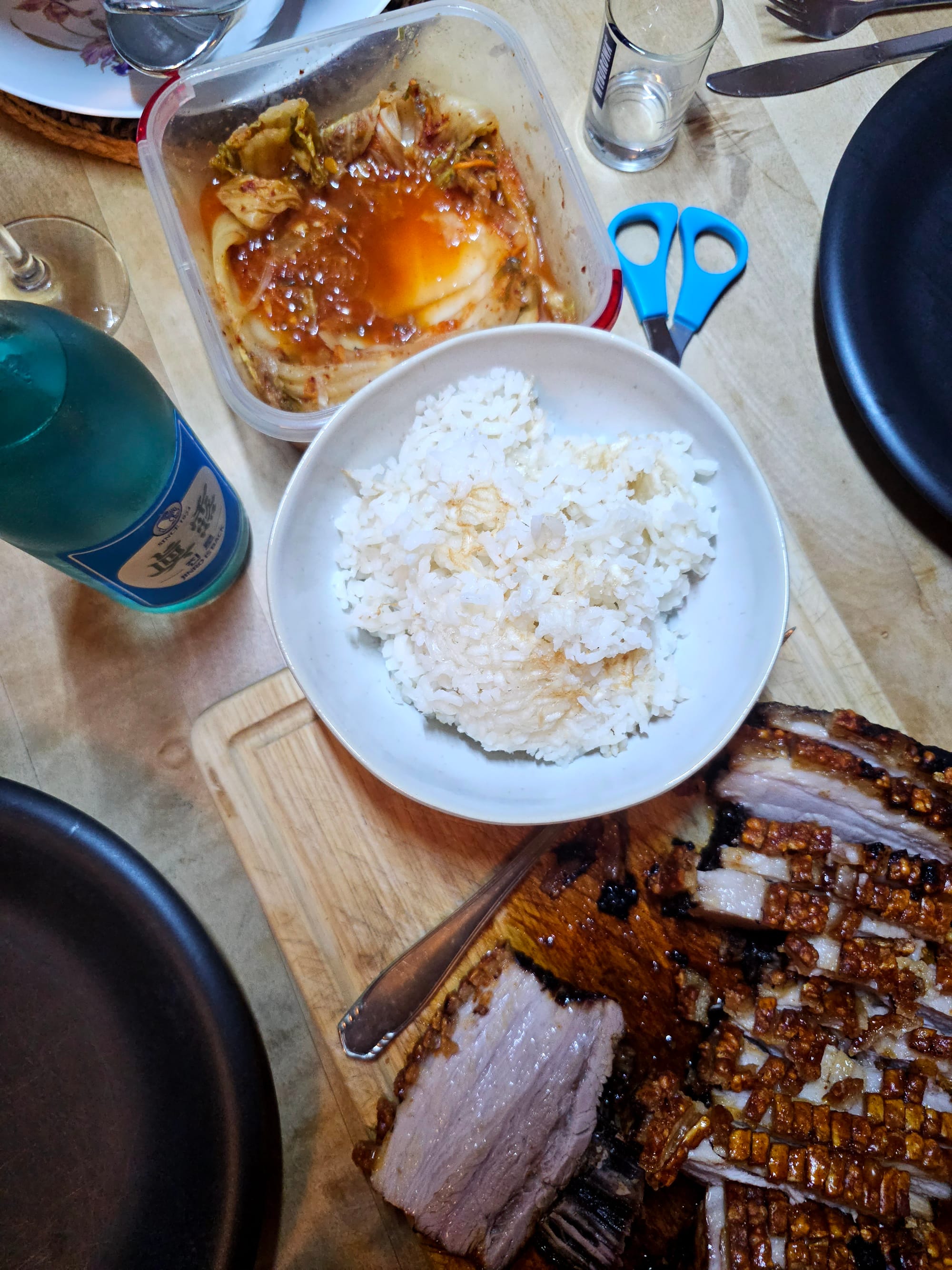 Kimchi, crispy pork belly, rice and Soju on a wooden table 