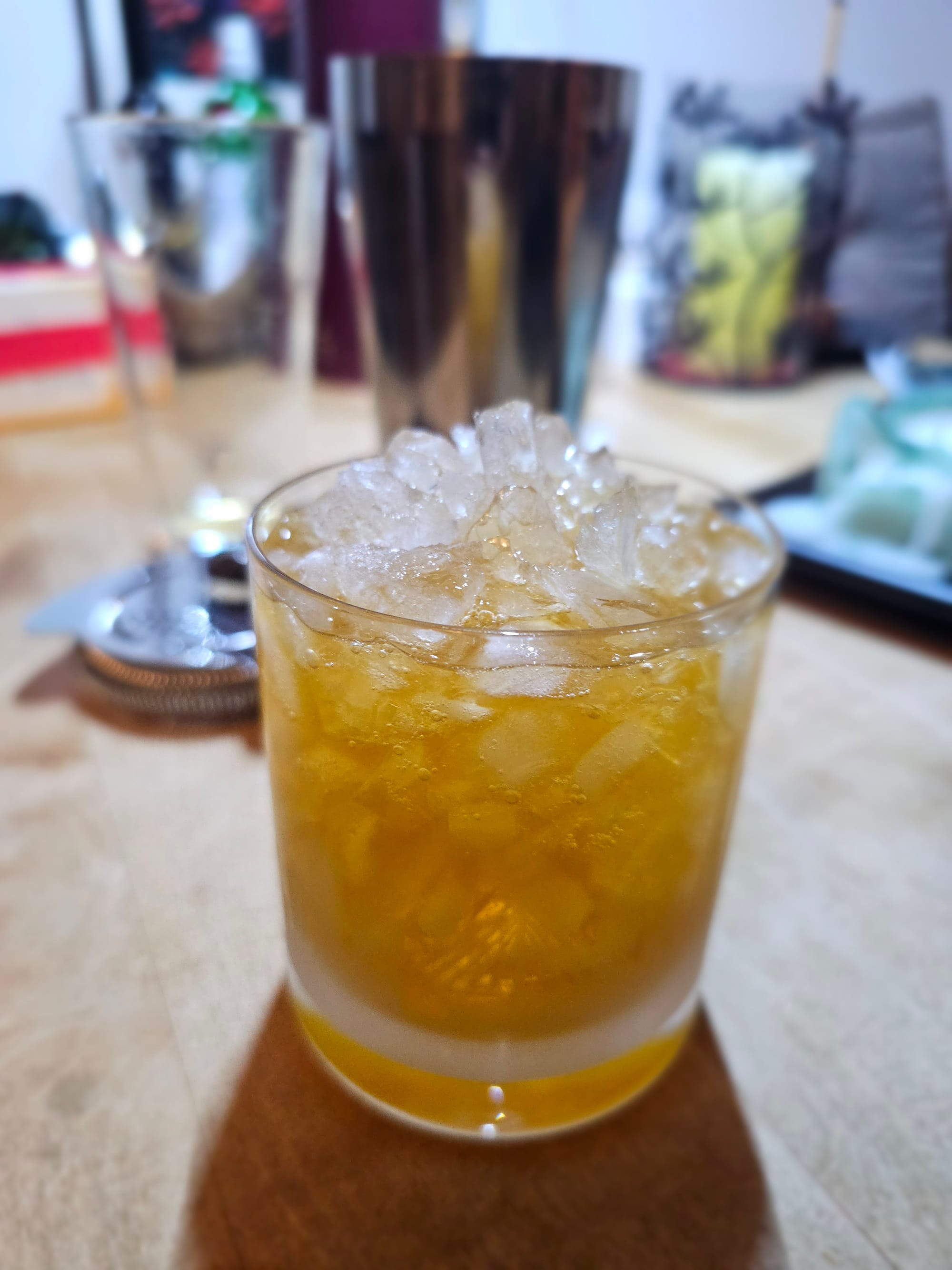 Yellow liquid in plenty of pebbled ice in a double old fashioned glass. 