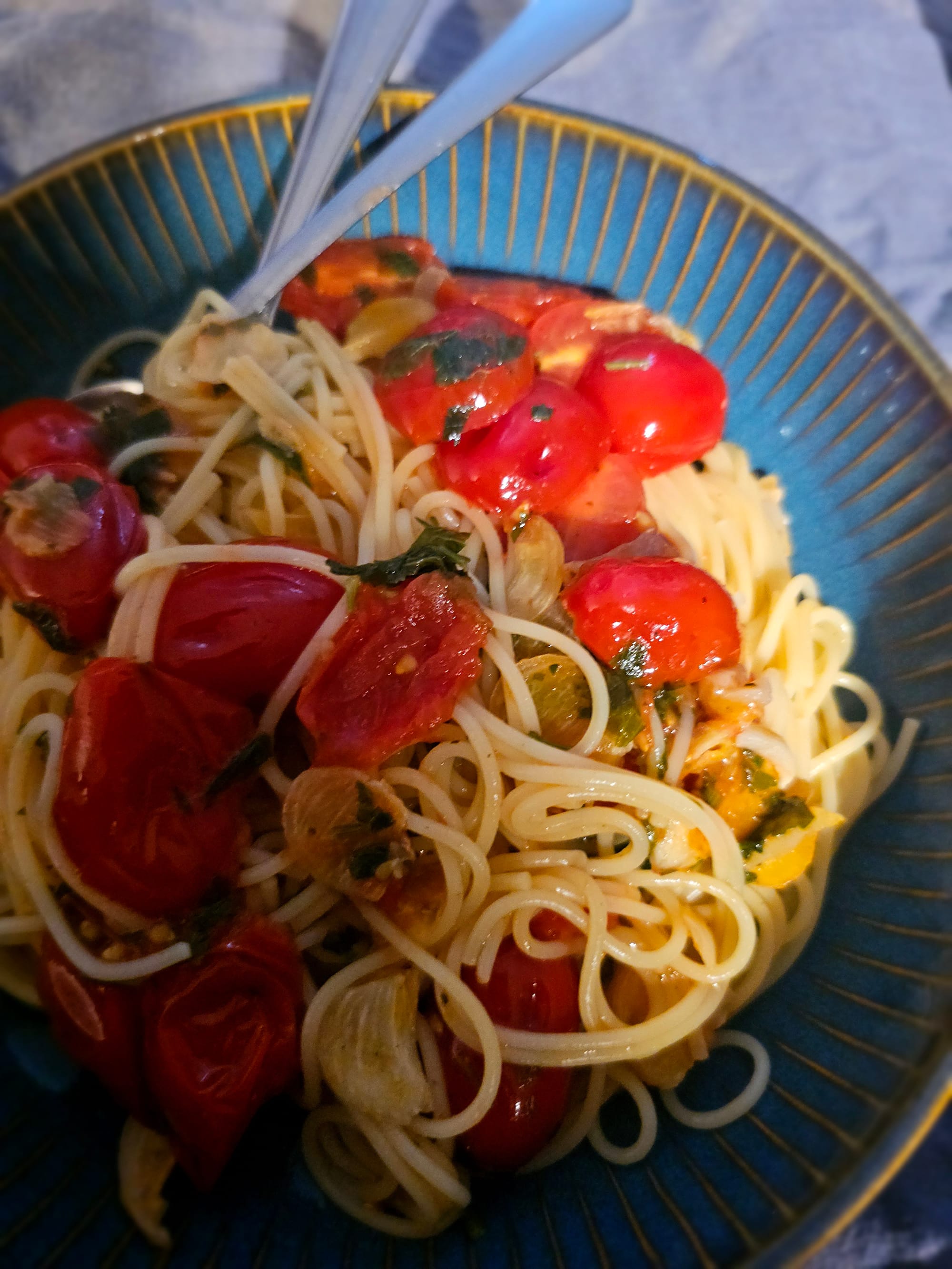 Tomatoes, garlic and spaghetti in a blue dish 