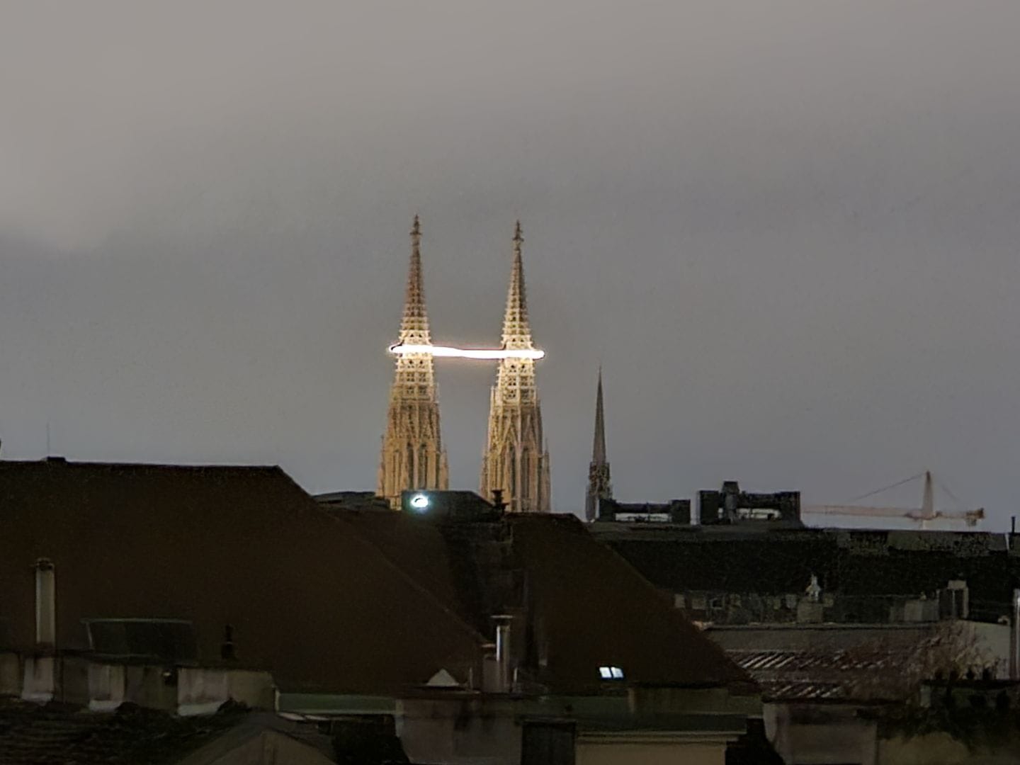 The two towers of the Votiv church in Vienna enveloped by a loop of light.